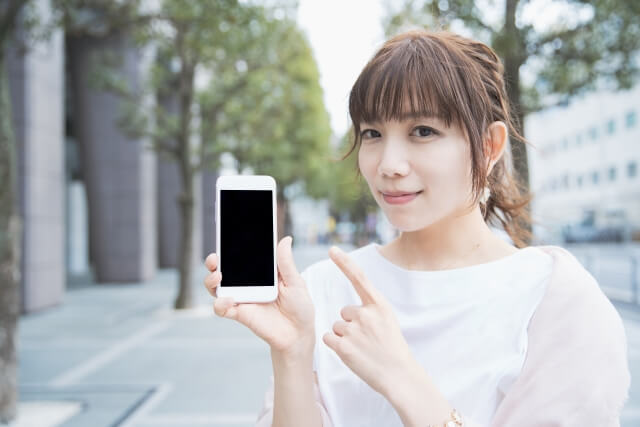 スマホを指差す女性