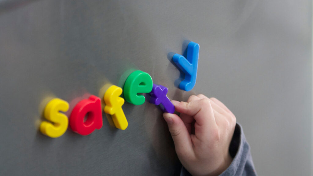 カラフルなアルファベットでsafetyと並べる子どもの手