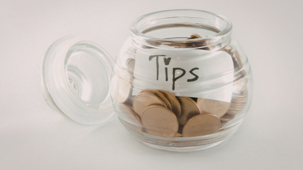Tipsと書かれたガラス瓶にコインが入っている