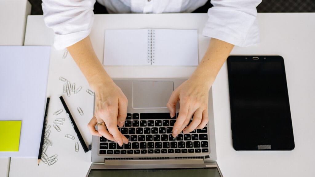 ノートパソコンで登録作業をする人の手元
