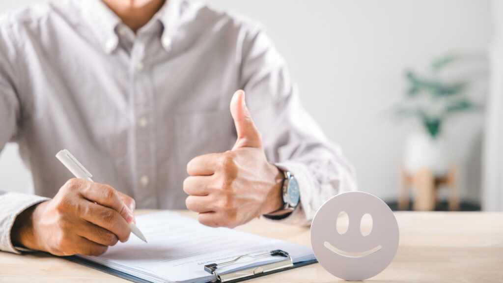 親指を立てる人と笑顔のスマイルマーク